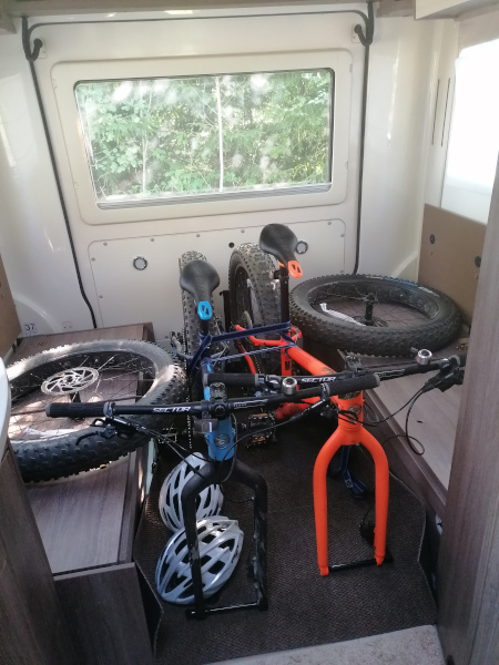 Bürstner Brevio -matkailuauton takaosa: pöytäryhmä on poistettu ja kaksi polkupyörää on pakattuna kuljetusta varten.